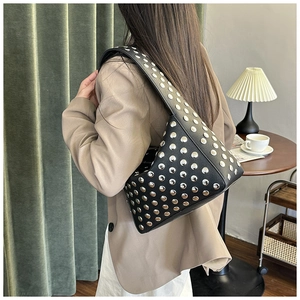 Detail of black pebbled leather underarm bag featuring heavy silver rivet stud decoration