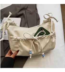 Dettaglio borsa a tracolla plissettata bianco off-white con tasca frontale per smartphone
