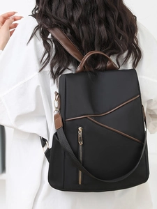 Minimalist black soft leather backpack for women with brown trim and geometric zipper