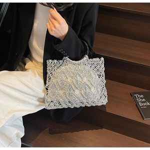 Detail der silbernen Perlen-Strandtasche mit runden Metallgriffen und weißem Inlay
