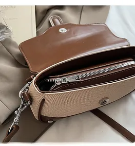 Close-up of contrast color patchwork crossbody bag showing interior zipper and smooth texture