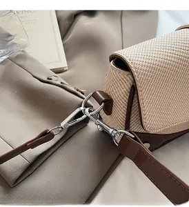 Detail of vintage square bag showing woven texture, brown leather trim and silver hardware