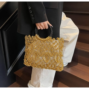 Detail der goldene hohl gewebte Netztasche mit runden schwarz-goldenen Henkeln