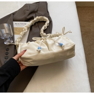 Dettaglio borsa a nuvola plissettata bianco crema con coulisse di perline in PU
