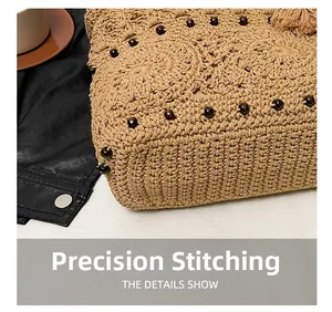 Close-up of precise stitching and woven texture on a straw bag with brown wooden beads