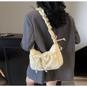 Dettaglio della borsa a spalla plissettata bianco crema con fiocco e perline decorate