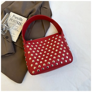 Detailed view of a red leather hobo bag with silver studs and a chic wide strap