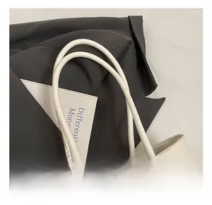 Detail of woven white leather tote bag with stylish plush doll pendant and metal buckle