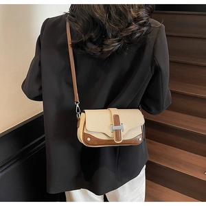 Detail of vintage patchwork crossbody bag with metallic H-clasp and leather strap