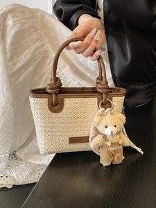 Borsa tote minimalista in paglia intrecciata con manici in pelle e ciondolo orsetto