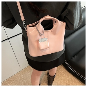 Detail of pink glossy leather tote bag with mini bag charm and silver metal hook