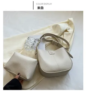 Close-up of beige lychee texture leather shoulder bag with matching mini storage pouch