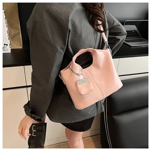 Detail of pink PU leather tote bag featuring a hanging square coin purse and silver hardware