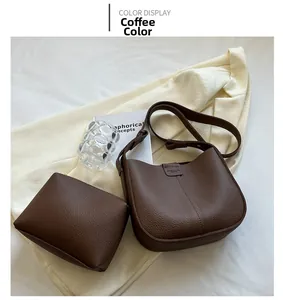 Coffee brown pebbled leather crossbody bag and pouch set on a minimalist background