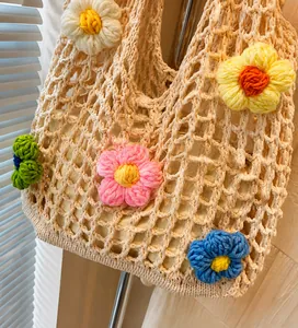 Detail der hohlen Web-Schultertasche mit bunten Strickblumen und Stoff-Innenbeutel