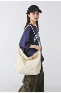 Detail of cream canvas bag showing large side pockets and soft cotton fabric texture