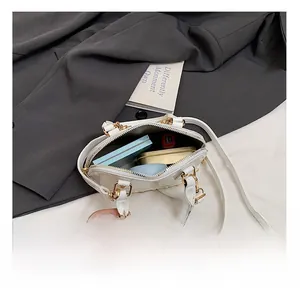 Interior view of white patent leather shell bag showing space for makeup and lipstick