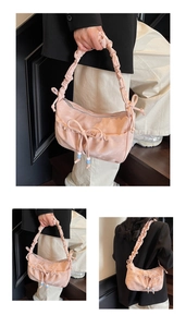 Dettaglio della borsa in raso rosa con grande fiocco e perline decorative
