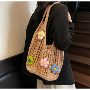 Detail of hand-woven hollow tote bag featuring colorful 3D crochet flowers on beige mesh