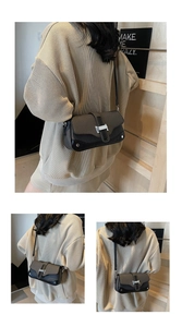 Detail view of retro gray crossbody bag with black trim and silver H-shaped buckle closure