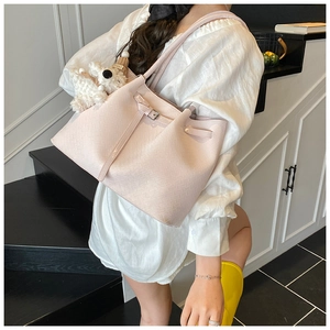 Detail of pink woven texture bucket bag featuring a cute white puppy plush charm