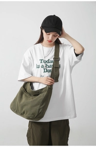 Detail of army green large canvas bag showing adjustable strap and crescent shape