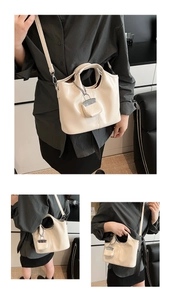Close-up of cream leather bucket bag showing shiny texture and mini coin purse charm