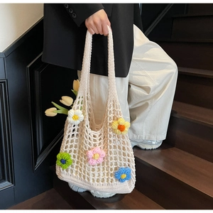 Detailed close-up of handmade hollow knit shoulder bag with colorful 3D crochet flowers