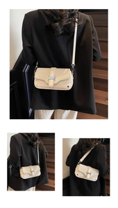 Detail of cream leather and woven fabric crossbody bag with silver H-shaped buckle