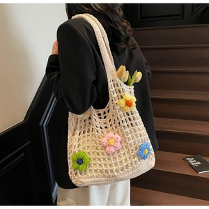 Detail of hollow woven shoulder bag with colorful 3D flower accents and tulip decoration