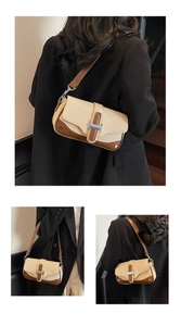 Detail of woven straw bag featuring brown leather trim and silver H-shaped buckle
