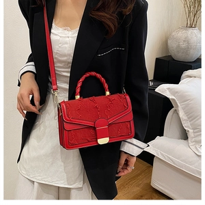 Dettaglio della borsa in tweed rosso con chiusura in metallo dorato e manico intrecciato