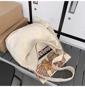 Detail of spacious canvas shoulder bag showing thick texture and interior capacity for books