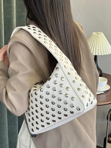 White leather shoulder bag with silver studs for women, shown from a rear side view