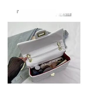 Internal view of a white quilted chain bag showing capacity for phone and cosmetics