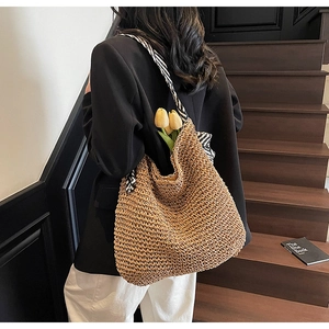 Straw shoulder bag with striped scarf detail shown on model in a summer beach style