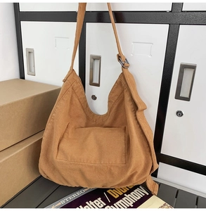 Detail of dark brown canvas hobo bag with adjustable strap and front utility pocket