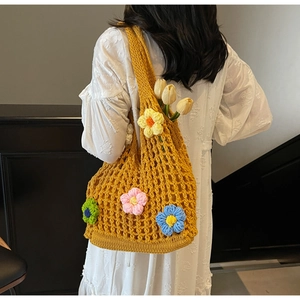 Detail of yellow hollow knit shoulder bag with handmade 3D crochet floral ornaments