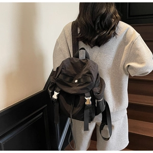Detail of waterproof nylon backpack featuring dual silver metal buckles and side zipper
