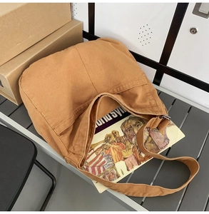 Detailed texture of camel canvas hobo bag placed on a grey striped bench for daily commute