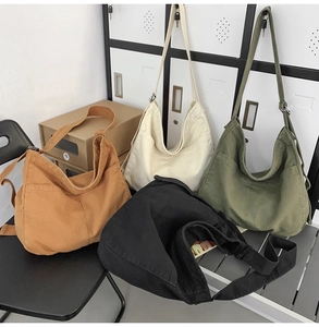 Various colors of large canvas hobo bags displayed on a vintage chair and locker
