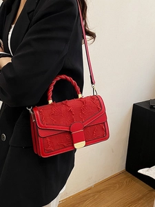 Borsa a mano chic in tweed rosso ricamato con manico a spirale e tracolla su blazer nero