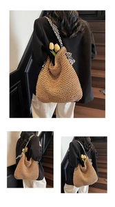 Detail of hand-woven straw tote with black and white twill ribbon handles and floral decor