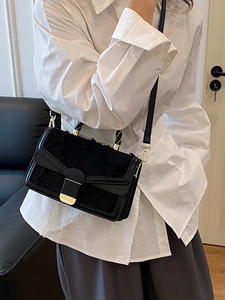 Borsa a tracolla nera minimalista con ricamo e chiusura dorata indossata da modella