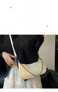 Detailed close-up of a white leather crescent underarm bag with elegant metal chain decor