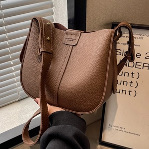 Brown litchi grain faux leather saddle bag with adjustable strap and metal buckle detail