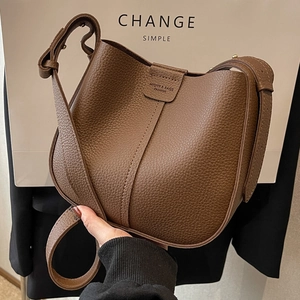 Dark brown pebble leather bucket bag with adjustable strap and vertical stitching detail