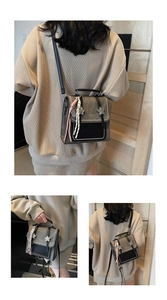 Detail of vintage grey textured backpack with star buckle, tassels, and hand stitching