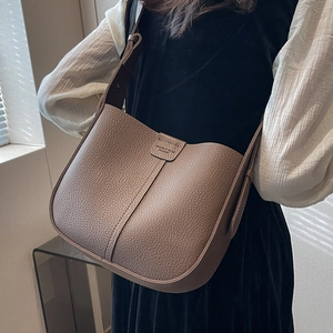 Light brown pebble leather crossbody bucket bag with adjustable strap and embossed detail