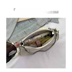 Top view of open cream baguette bag showing interior capacity with phone and cosmetics